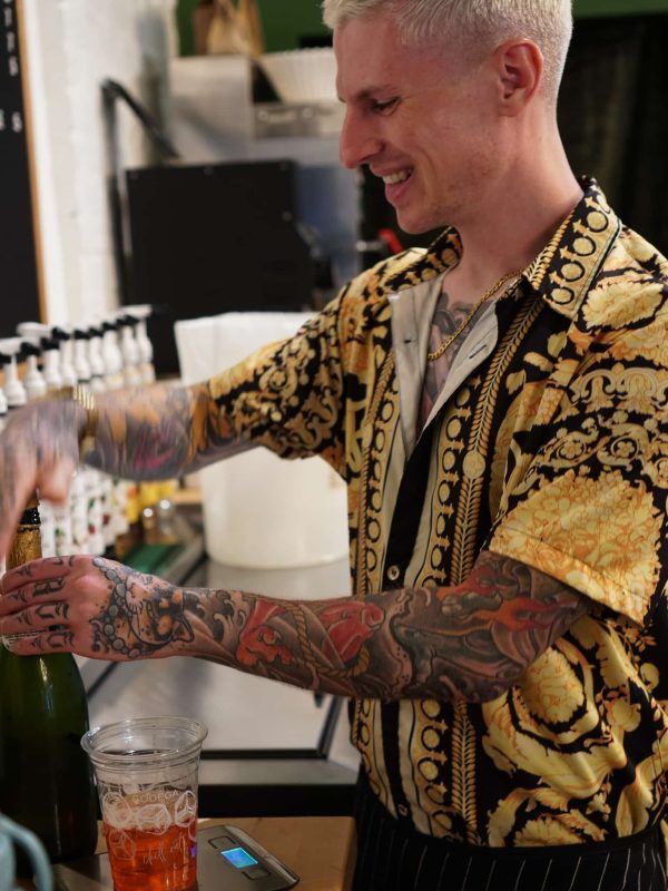 Employee at a late-night coffee shop making a hand-crafted cocktail beverage.